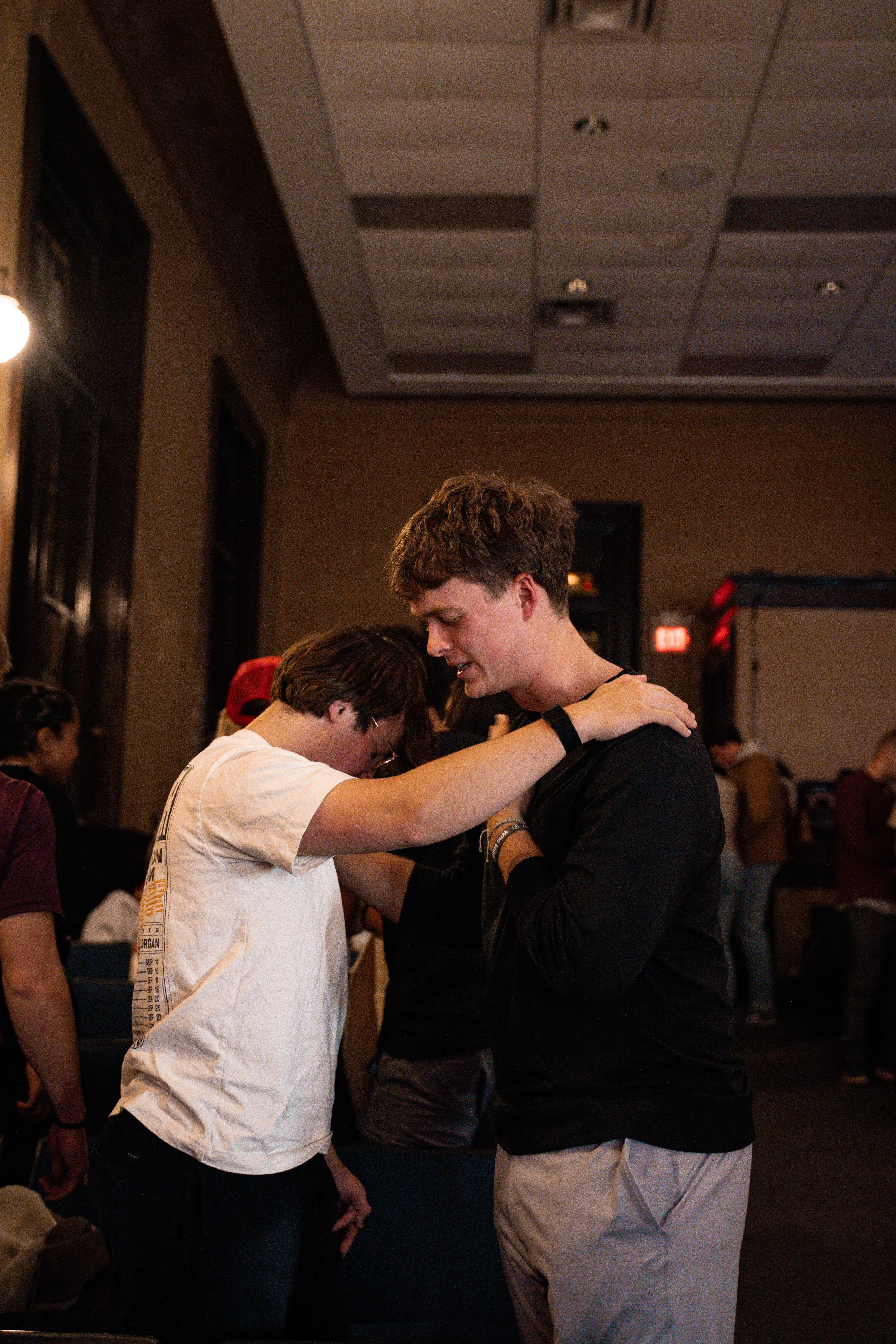 Two friends praying for each other after a Monday Nights gathering in Nashville