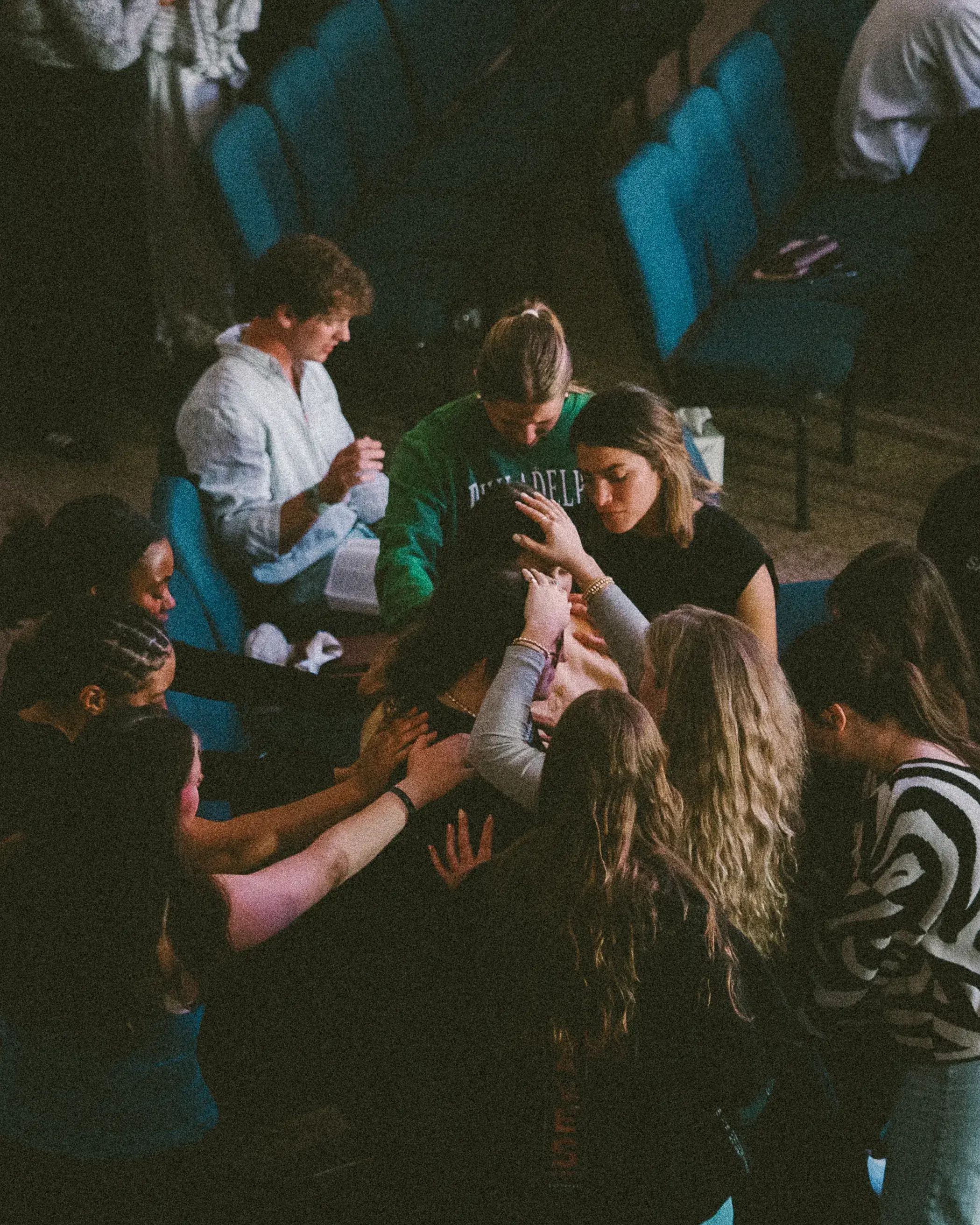 Students laying hands on a friend and praying for breakthrough at Monday Nights in Nashville